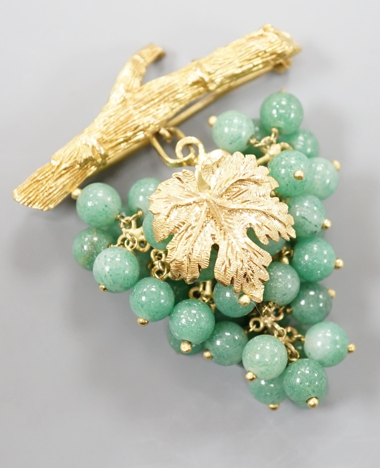 A 20th century continental 18k yellow metal and adventurine quartz bead set brooch, modelled as a bunch of grapes hanging from a branch, 59mm, gross weight 30.4 grams.